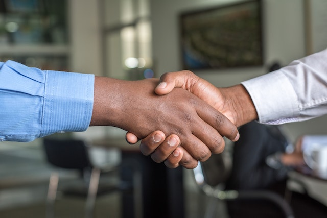 investor-and-property-manager-shaking-hands-over-desk