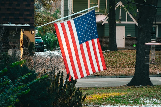 usa-american-flag-hanging-from-side-of-house