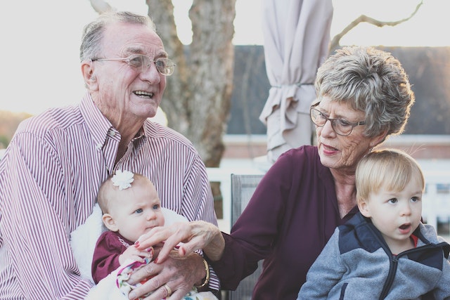 elderly couple with toddlers on their laps